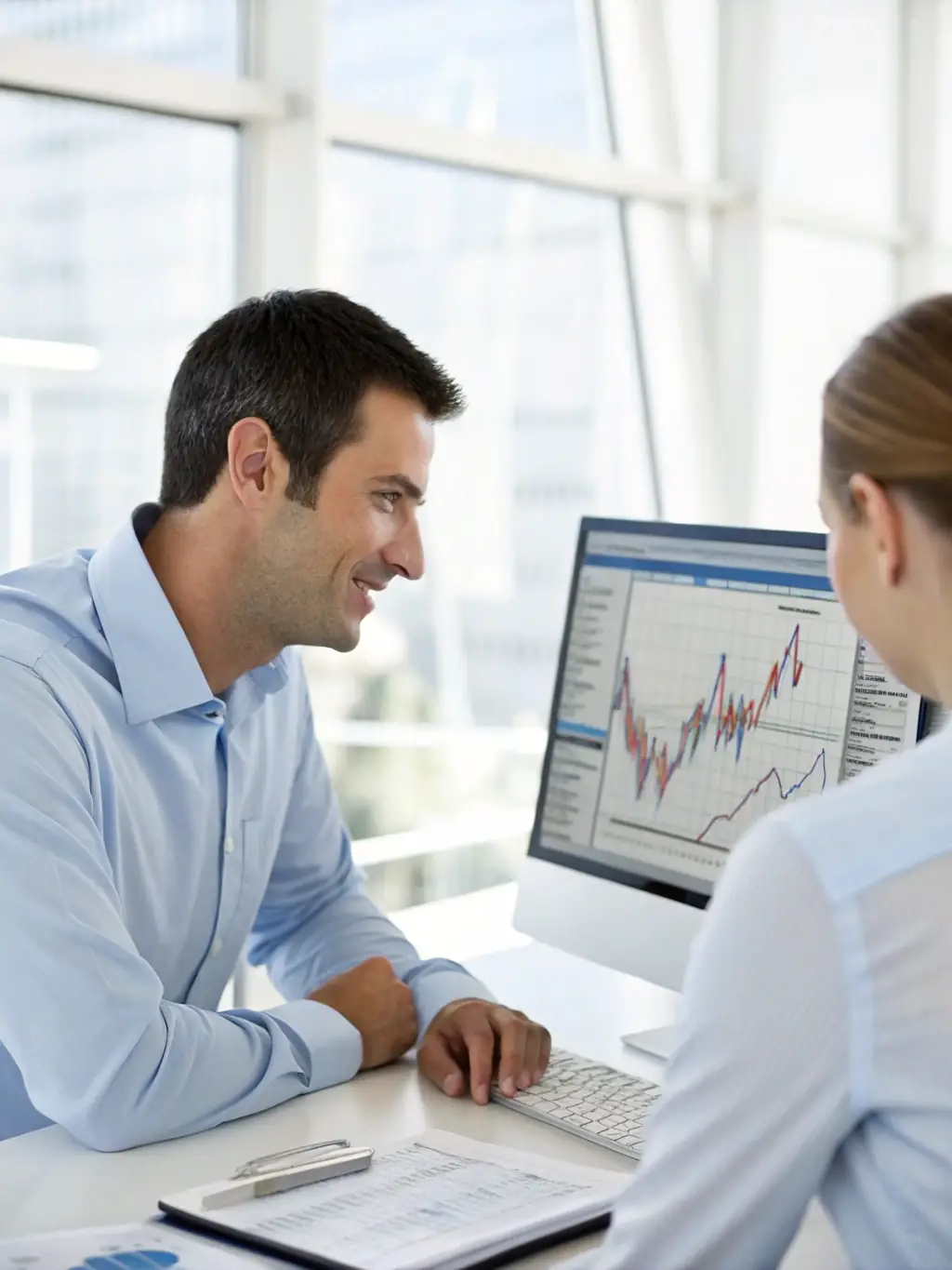 A professional advisor in a suit, reviewing financial documents with a client in a modern office setting, symbolizing personalized investment strategy consultation.